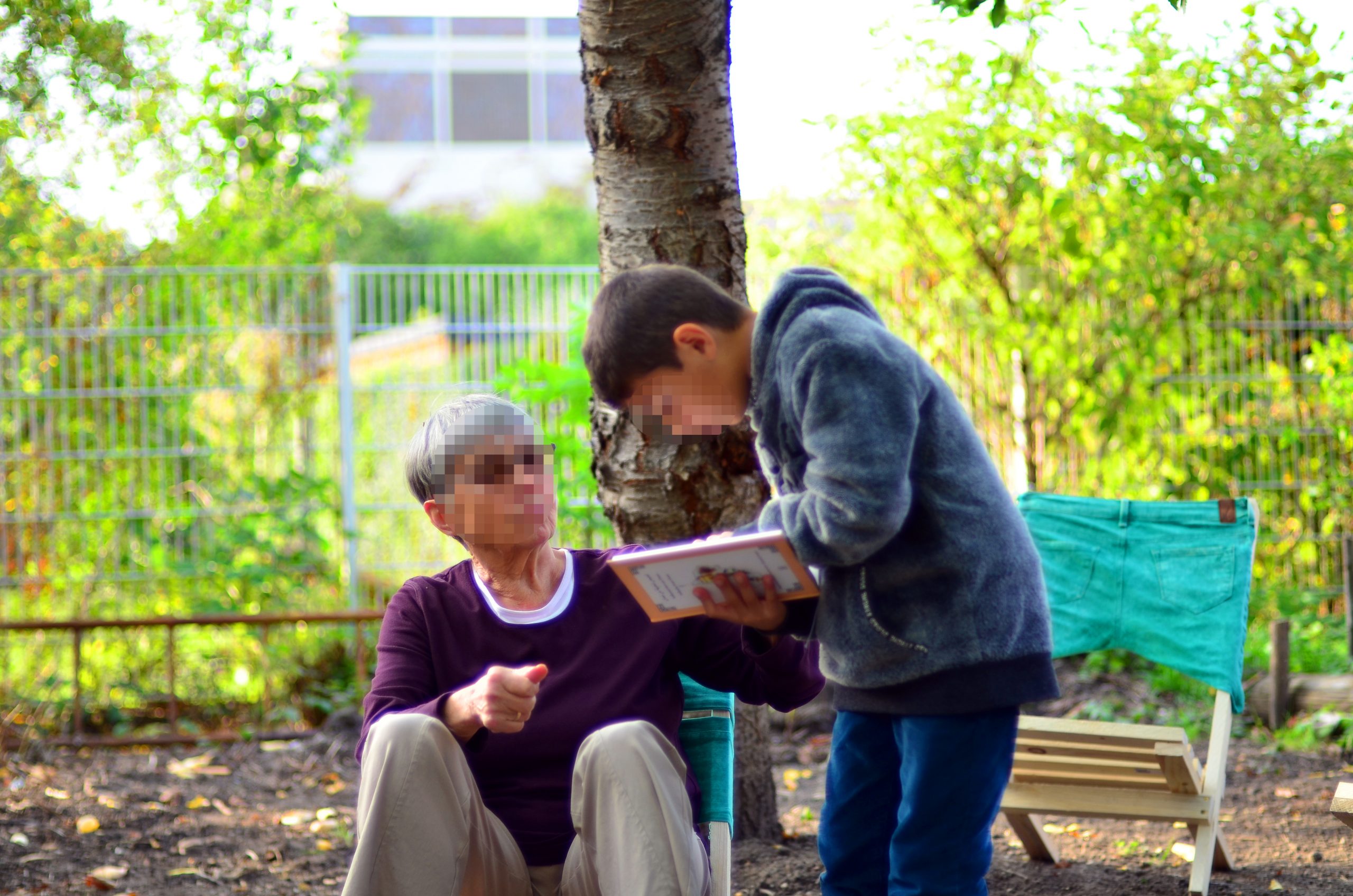 Ein Junge und eine ältere Frau schauen in ein Buch